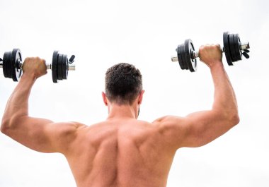 Eylemler koçlardan daha yüksek sesle konuşur. Sırtı ve kolları güçlü bir sporcu. Spor malzemeleri. Vücut geliştirme sporu. Spor yaşam tarzı. Aptal egzersiz salonu. Dambıl gibi arkadan bakan kaslı bir adam.