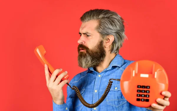 Мужчина с усами держит винтажный телефон. винтажное устройство связи. Бизнесмен разговаривает по винтажному телефону в своем офисе. гибкий бизнес. старинный стационарный телефон. hello 80s — стоковое фото