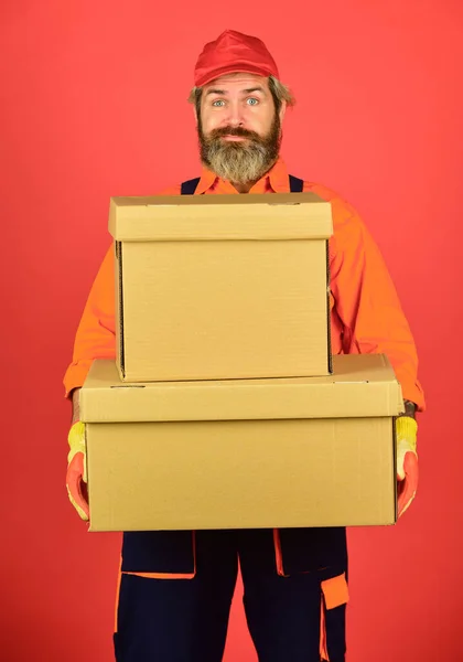 Man builder in boilersuit hold boxes. moving to new apartment. happy man cardboard box. carrying boxes inside the building. unpacking moving boxes. new house at moving day. Love Where You Live — Stock Photo, Image