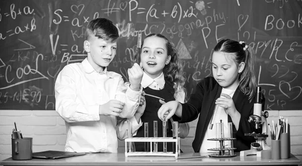 Κορίτσια και αγόρια μαθητές διεξάγουν σχολικά πειράματα με υγρά. Έλεγξε το αποτέλεσμα. Μάθημα χημείας. Εργαστήριο σχολείου. Μαθητές ομαδικών σχολείων μελετούν χημικά υγρά. Δοκιμαστικοί σωλήνες με χρωματιστές ουσίες — Φωτογραφία Αρχείου