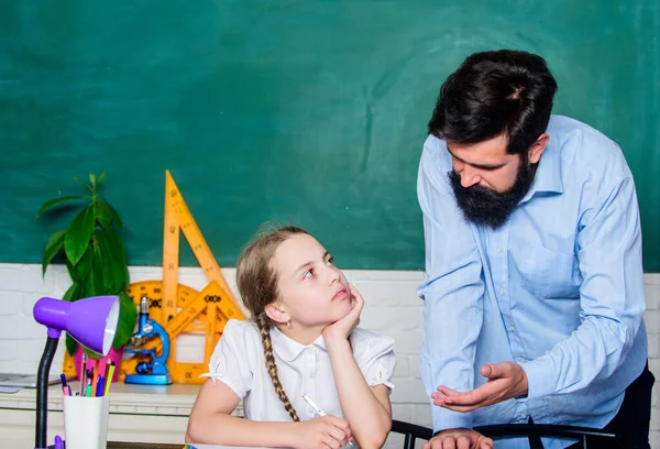 Soukromá lekce. Domácí výuka s otcem. Pedagogické dovednosti. Školní učitelka a školačka. Muž vousatý pedagog. Přísný pedagog. Dělám papírování pro domácí úkol. Unavené dítě bez motivace studium učit — Stock fotografie