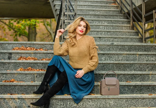 Fall fashion trend. Wearable trends. Layer oversize knit over girly skirt. Fall outfit formula. How to Style Sweater and Skirt Combo for Fall. Woman with gorgeous hairstyle sit on stairs outdoors — Stock Photo, Image