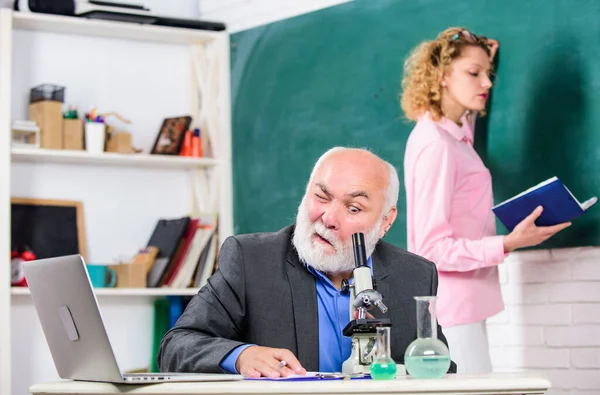 Zkušenost. lekce biologie. Věda a biotechnologický výzkum. student a učitel s laptopem. vzdělávání chemie. Zpátky do školy. studentka na palubě. zralý učitel s kádinkou a mikroskopem — Stock fotografie