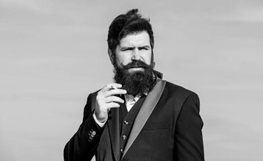 Rahatlatıcı ama zararlı bir alışkanlık. Sakallı ve bıyıklı bir adam sigara tutuyor. Sigara içen sakallı hippi. Sigaralı adam nikotin etkisinden hoşlanır. Sigara içmenin zevki