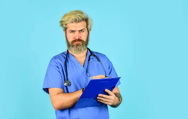 Він одягнений у стетоскоп. медсестра тримає зв'язувач і носить стетоскоп. зрілий бородатий чоловік лікар з папкою в однорідному положенні. Портрет серйозної медсестри з текою — стокове фото