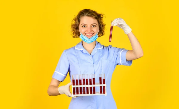 Test your blood. scientist in face mask and gloves holding test tube with red substance. Investigator checking test tubes. woman wears protective mask. Making lab Experiment — Stock Photo, Image