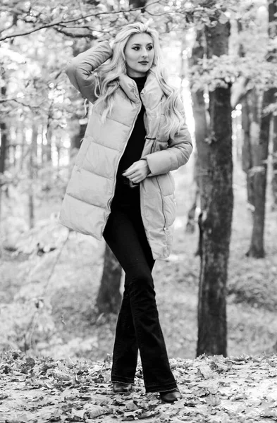 Girl fashionable blonde walk in autumn forest. Jackets everyone should have. Best puffer coats to buy. How to rock puffer jacket like a star. Puffer fashion concept. Woman wear warm pink jacket