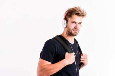 Gittiğin her yerde müziğin tadını çıkar. Müzik uygulaması indir. Gençlik müziğinin tadı. Müzik dinleyen yakışıklı öğrenci. Modern insan konsepti. Saç stili değiştirilmiş adam plastik kulaklık takıyor.