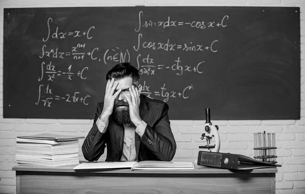 Teaching dumb students. No hope for better. Tired and exhausted. Teacher mature man. Fed up. Difficult work. Emotional burnout. Teacher give up. Hate his job. Man desperate teacher in classroom
