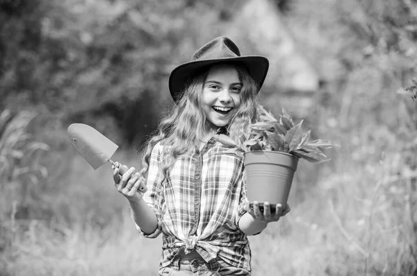Boldogság. Tavaszi szezon. Gyenge nyár. Egy kislány ásóval ültet. Földi nap. környezetvédelmi ökológia. zöld természetvédelem. Kislány farmer törődik növény pot. gazdálkodás és mezőgazdaság — Stock Fotó