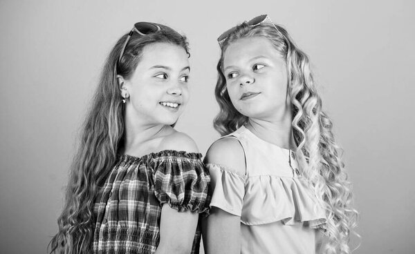 Девочки с длинными вьющимися волосами носят солнечные очки. Солнечные очки летний аксессуар. Летний тренд. Маленькая модница. УФ-защита. Здоровье глаз. Купите настоящие очки. Магазин оптики. Милые маленькие дети модные девочки
