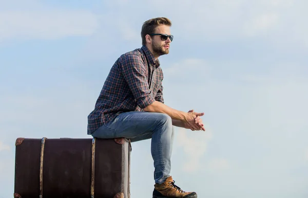 Temps de vacances. Agence de voyage. Homme assis sur une valise avant le voyage. Voyage d'affaires. Un beau voyageur. Guy à l'extérieur avec valise vintage. Concept de bagage. Voyagez avec vos bagages. Blogueur de voyage — Photo