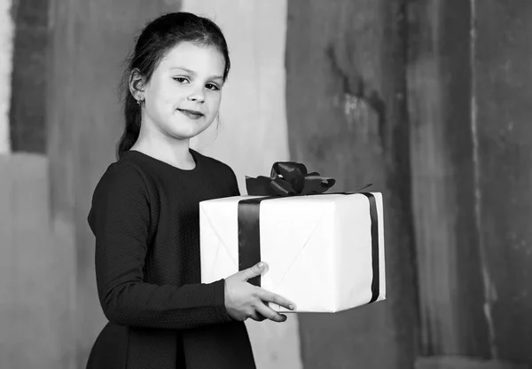 Отдавай. Счастливого Рождества и счастливых праздников. Зимние каникулы. Маленькая девочка держит подарочную коробку. Ребенок держит коробку красочный фон. Рождественские подарки. Семейная традиция. Подарочный пакет — стоковое фото