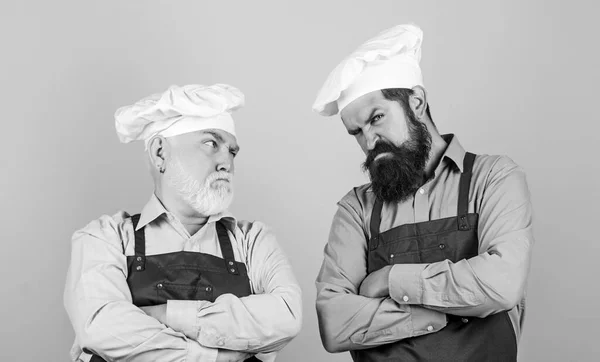 Mature bearded men professional restaurant cooks. Family restaurant. Chef men wear aprons. Father and son culinary hobby. Cafe workers. Restaurant kitchen. Culinary industry. Restaurant staff