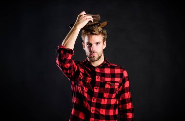 Erkek traşsız kovboy siyah arka planı. Erkeklik ve vahşet kavramı. Kovboy tavırlarını moda pozu olarak benimse. Yurtdışındaki Amerikalıların mimari imajı. Kovboy hayatı son derece romantikleşti.