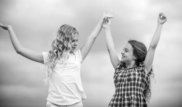 Girls with healthy natural curly hair. Curly and gorgeous hairstyles. Beauty procedure. Adorable kids. Beautiful sisters. Hairdresser salon services. Two little girls kids with long curly hair — Stock Photo, Image