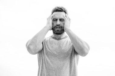 Sporcu, atletik vücutlu. Spor salonunda koç. Antrenmandan sonra. Mavi tişörtlü bir sporcu. Spor giyim modası. Sakallı bir erkek. Yorgun adam beyazı soyutladı. Başı ağrıyor. Yorgun hissediyorum.