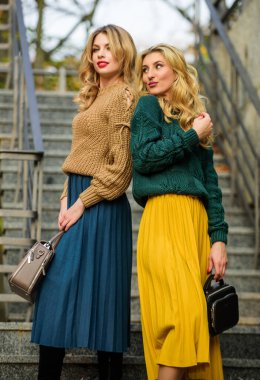 Renkler uyuşuyor. Kişisel stilistlik hizmeti. Süveter etek modası. Birbirimizi tamamlıyoruz. Eşleşen kıyafetler. Kadın kardeşler dışarıda arka planda. Vogue konsepti. Sarışın kızlar uyumlu kıyafetler giyer.