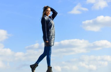 Sonbahar ve bahar tarzı. Gökyüzü arka planında genç ve güzel bir kadın. Bulutların üstünde. Uzaklara bakmak, özgürlük duygusu. Gelecek ve başarı. Yaşam tarzı konsepti. Gayri resmi ceketli modacı kız.