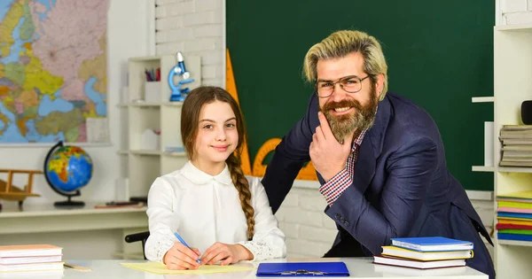 Niña y hombre contra pizarra. concepto del día del conocimiento. niño con maestro en el aula en la escuela. Feliz día de los maestros. profesor y colegiala en la lección. de vuelta a la escuela —  Fotos de Stock