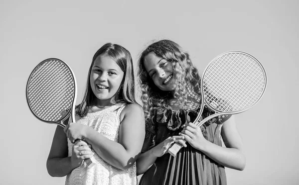 休息一下吧快乐和快乐。体育比赛。夏季户外运动。打网球。童年的幸福和姐妹情谊。有网球拍的小女孩。夏季体育活动。精力充沛的孩子 — 图库照片
