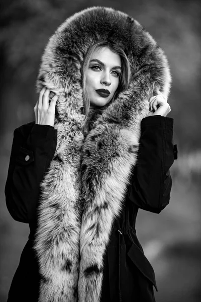 Fake fur fabric. Elegant girl walk in autumn park. Fur garments. Really warm and cozy. Expensive clothes. Luxury segment brand. Luxury fur. Beauty and fashion. Woman wear coat with huge furry hood