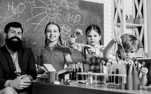 Μετά τα σχολικά κλαμπ. Εξηγεί τη χημεία στα παιδιά. Συναρπαστική χημική αντίδραση. Δάσκαλοι και μαθητές δοκιμάζουν σωλήνες στην τάξη. Ενδιαφέροντα μαθήματα. Σχολική εκπαίδευση. Σχολικό πείραμα χημείας — Φωτογραφία Αρχείου