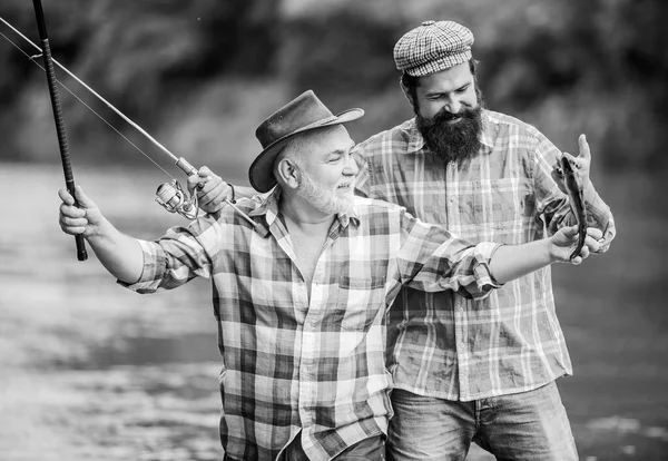 Nonno e amici maturi. Famiglia di pescatori. Asta da placcaggio. Attrezzature da pesca. Hobby sport. Pesca con mulinello. Soleggiata giornata estiva al fiume. Pesca attività pacifica. Padre e figlio pesca — Foto Stock