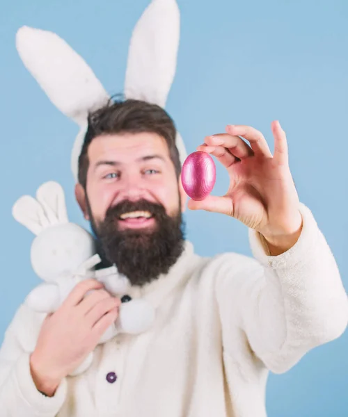 Великодній символ концепції. Мій дорогоцінний. Бородатий чоловік носить дурні вуха кролика. Хіпстер милий кролик довгими вухами синій фон. Великодній кролик. Розважатися. Смішний кролик з бородою і вусами тримає рожеве яйце — стокове фото