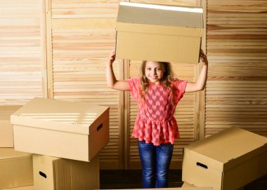 Taşınma konsepti. Teslimat servisi. Kutu ve depo. Küçük çocuk taşınma için hazırlan. Ailenin yerini değiştirmek heyecan verici olabilir ama çocuklar için de stresli olabilir. Kutuları yeniden yerleştiren kız çocuğu