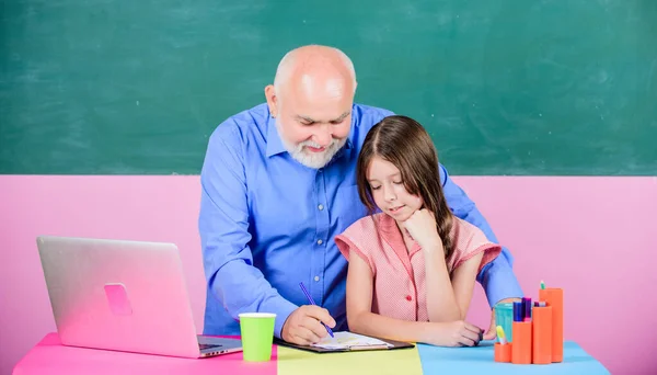 Centra voor excellentie. klein meisje met man tutor studie op laptop. online onderwijs. Terug naar school. online winkelen op school. Ik schrijf een opstel. De lerares helpt schoolmeisje. moderne technologie — Stockfoto