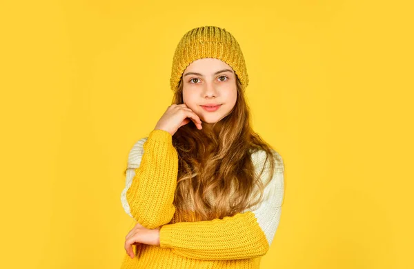 Barndoms lycka koncept. tonåring flicka gul bakgrund. En liten flicka i stickade kläder. Skönhet och mode. bli varm under vintersäsongen. kall väderprognos. Glad barn bära hatt och favorit tröja — Stockfoto