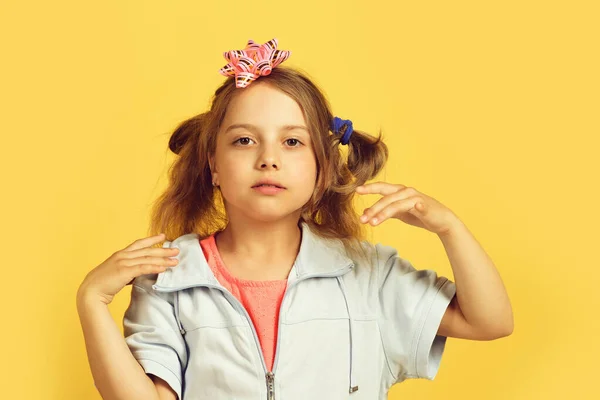 Meisje met geconcentreerde gezicht geïsoleerd op warme gele achtergrond — Stockfoto