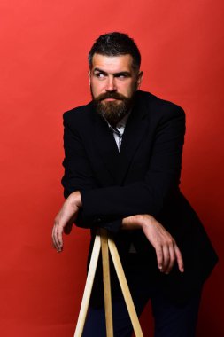 Maço erkek fotoğraf makinesi tripod üzerinde kırmızı bir arka plan üzerinde eğilir