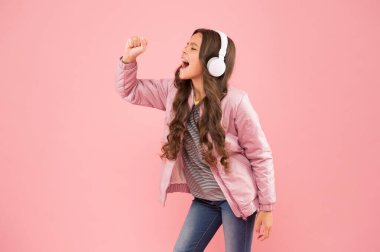 Onun bir yıldız olduğunu hayal et. Karaoke partisi eğlencesi. Eğlence ve eğlence. Bir şarkıya katılıyorum. Üzgün ve pembe görünümlü küçük bir kız. Küçük çocuk stereo sesi duyuyor. Kulaklıkla çalan eğlenceli şarkı