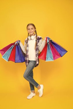 black friday. hurry up its total sale. Kids fashion. Sales and discounts. happy small girl after successful shopping. adorable child with heavy bags. Best outfit ever. holiday gifts in packages