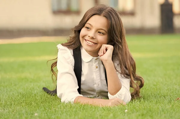 Las vacaciones son divertidas. Feliz niño pequeño disfrutar de las vacaciones escolares. Niña relajarse en la hierba verde durante las vacaciones. Día fuera. Vacaciones o vacaciones escolares. Vacaciones — Foto de Stock