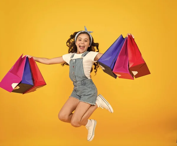 Real happiness. happy small girl after successful shopping. energetic child jump with heavy bags. holiday gifts in packages. cyber monday. hurry up its total sale. Kids fashion. Sales and discounts — Stock Photo, Image