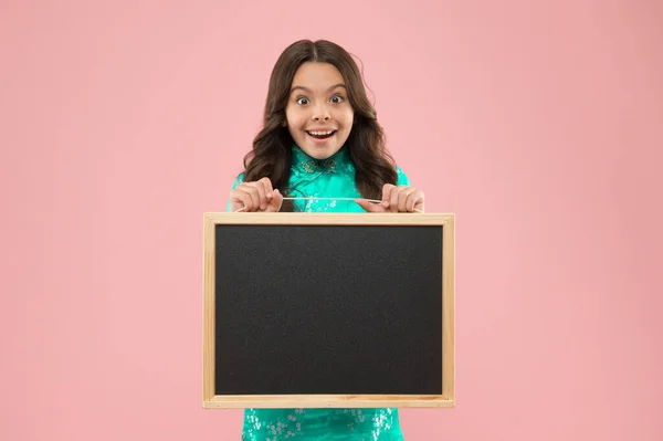 小さな子供が授業のために黒板を手に入れた。広告テキスト、コピースペースのBlackboard 。幸せな女の子は黒板ピンクの背景を保持します。明るい子は広告板を持ってる。広告・宣伝 — ストック写真