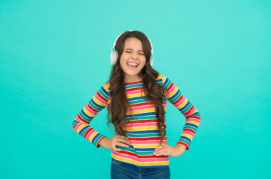 Enerjik ritim kavramı. İyi parça havayı iyileştirir. Mutlu küçük kız müzik dinliyor. Küçük çocuk kulaklıkla çalan şarkılardan hoşlanır. Gülen surat. Müzik mutlu duygular getirir. Neşelendirmek için melodi