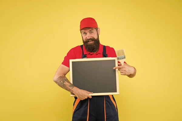 Homem trabalhador com pincel. Trabalhador normal do construtor. Reparação e renovação. Reparação rápida. Decoração criativa. A pintura funciona. Decorador barbudo segurar chalkboard espaço de cópia de propaganda. Dicas de reparação — Fotografia de Stock