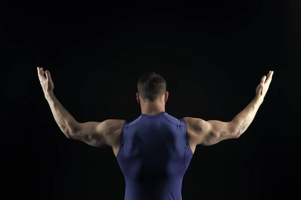 Atletik vücut geliştirmeci poz izole üzerinde siyah arka plan. — Stok fotoğraf