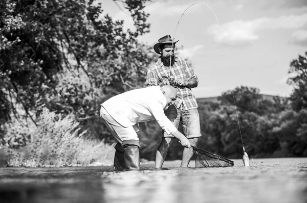 Legami familiari. padre in pensione e figlio barbuto maturo. Concetto di cattura e pesca. Buona amicizia tra pescatori. Due amici maschi che pescano insieme. hobby del pesce della mosca dell'uomo d'affari. pesca a riposo — Foto Stock