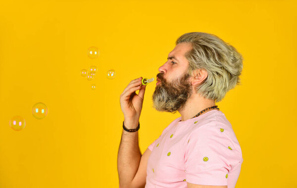 Blow inflate bubbles. Happiness and joy. Good vibes. Forever young guy. Positive. Infantility concept. Carefree man soap bubbles. Summer vacation. Happy playful bearded hipster and soap bubbles