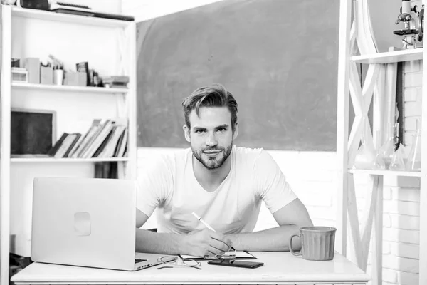 Vida universitaria en línea. profesor de la escuela utilizar el ordenador portátil y smartphone. concepto de educación moderna. de vuelta a la escuela. Mañana de trabajo. El hombre toma nota y bebe café. estudiante en el aula con taza de té — Foto de Stock