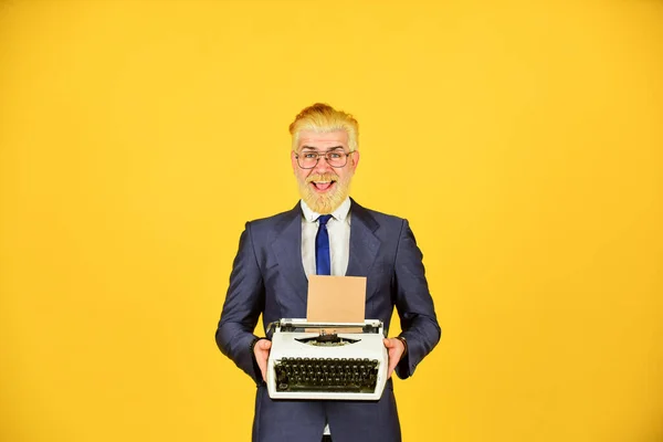 Writer stick old habits. Used goods store. Salesman vintage objects. Connoisseur of vintage values. Vintage typewriter. Businessman use retro technology. Mature man dyed beard hair yellow background — Stock Photo, Image