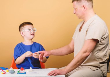 Tıp kavramı. Çocuk küçük doktor masa tıbbi aletleri oturup. Sağlık. Tıbbi muayene. Çocuk sevimli çocuk ve babası doktor. Hastane çalışanı. İlk yardım. Tıbbi yardım. Travma ve yaralama