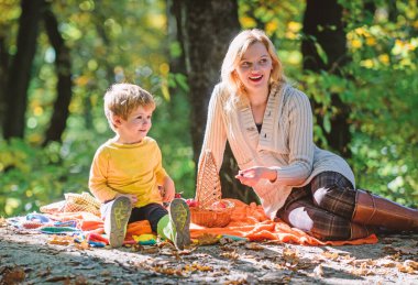 Anne ve çocuk ormanda yürüyüş yaparken rahatlatıcı. Aile pikniği. Anne güzel kadın ve küçük oğlu ekose rahatlatıcı orman piknik oturup. Doğada bahar pikniği için iyi bir gün. Doğayı birlikte keşfedin