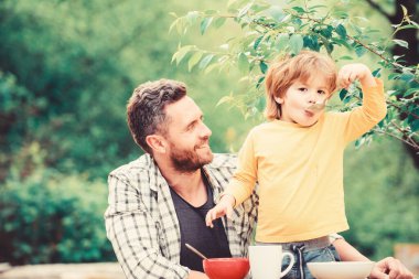 Aile akşam yemeği zamanı. mutlu babalar günü. Babası olan küçük çocuk tahıl yiyor. Yaz piknik. Sabah kahvaltısı. sağlıklı gıda ve diyet. Çocuk günü. Baba ve oğlu açık yeme. Mutlu aile konsepti