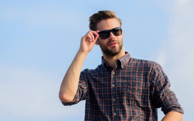 Sakallı adam gündelik tarzda. Seksi erkek gökyüzü arka planı. Erkekler güzellik cinselliği. Erkek modası. Çok moda görünüyor. Maço, tıraşsız bir adam. Gözlüklü iş adamı. Gerçek erkekler. Güven ve karizma